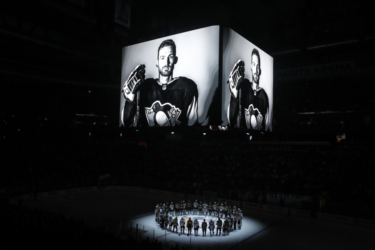 Oct 30, 2023; Pittsburgh, Pennsylvania, USA; Members of the Anaheim Ducks and the Pittsburgh Penguins stand at center ice for a moment of silence at the PPG Paints Arena to honor former Penguin forward Adam Johnson (on scoreboard) who was tragically killed in a hockey related accident in Europe.